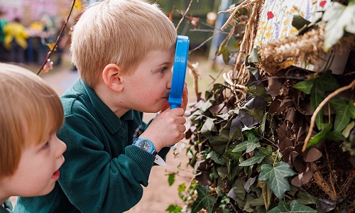 Disgybl Ysgol Gymraeg Trefynwy yn edrych drwy chwyddwydr